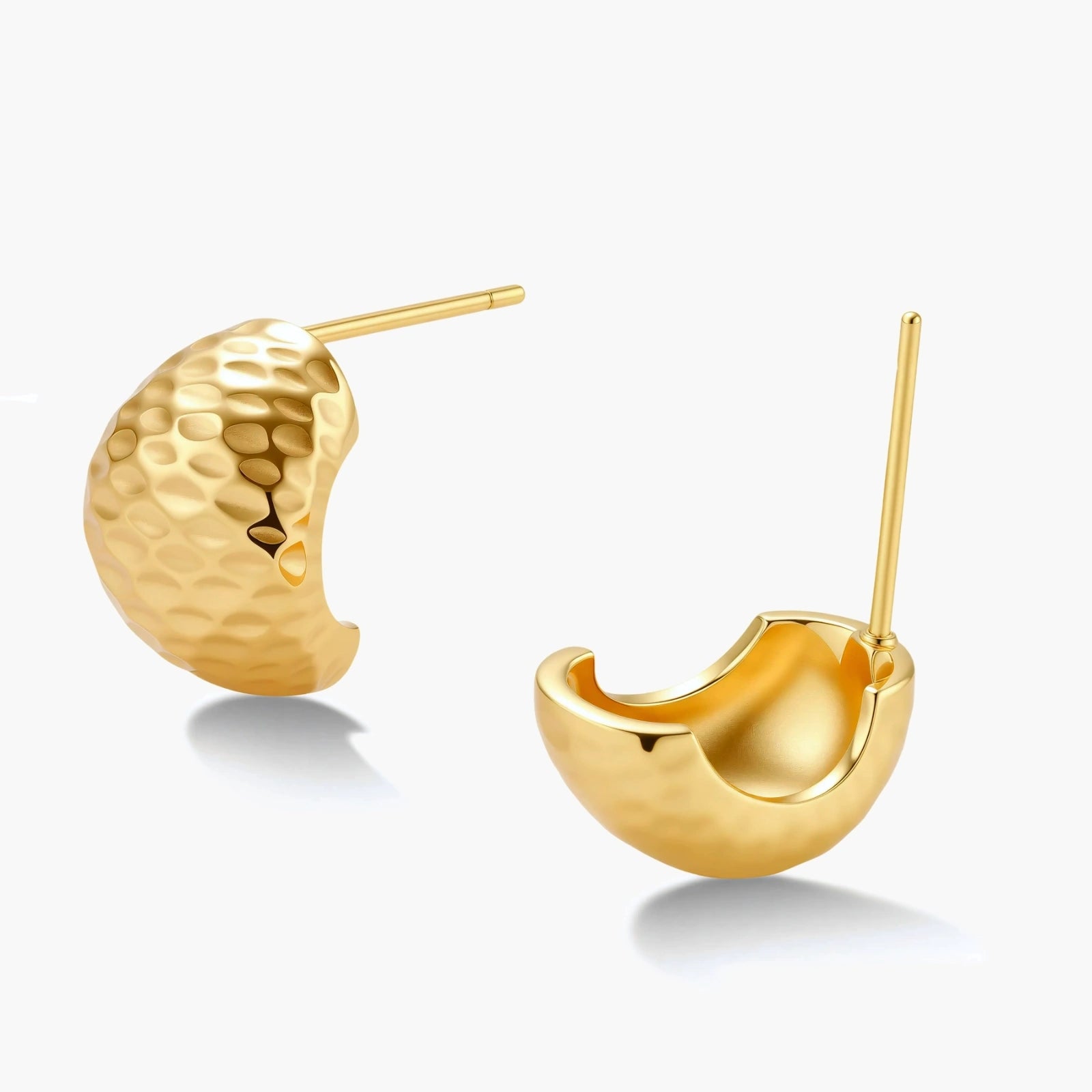 Pair of textured gold-plated sterling silver huggie earrings with dimpled surface finish on cream background.