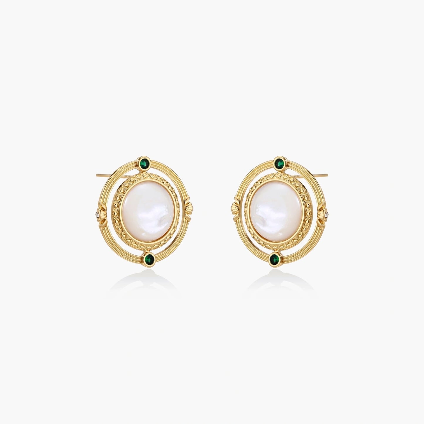 Circular gold stud earrings with iridescent mother-of-pearl center and green zirconia accents on cream background.