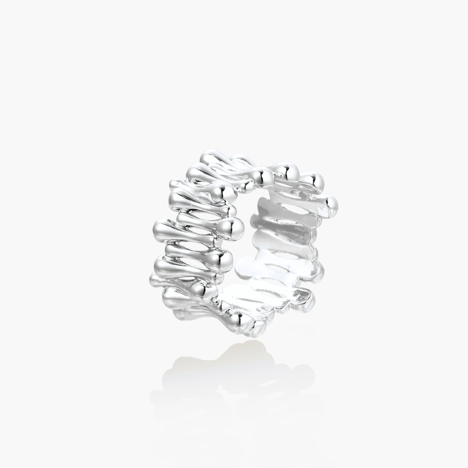 Wide band ring with sculptural wave ripples in polished white gold plated eco-brass on cream background