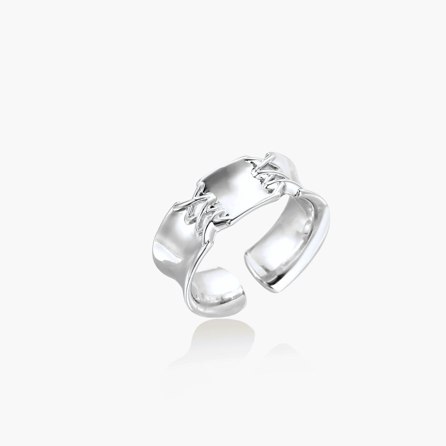 Adjustable silver-toned ring with sculptural stitch design across polished white gold-plated brass band