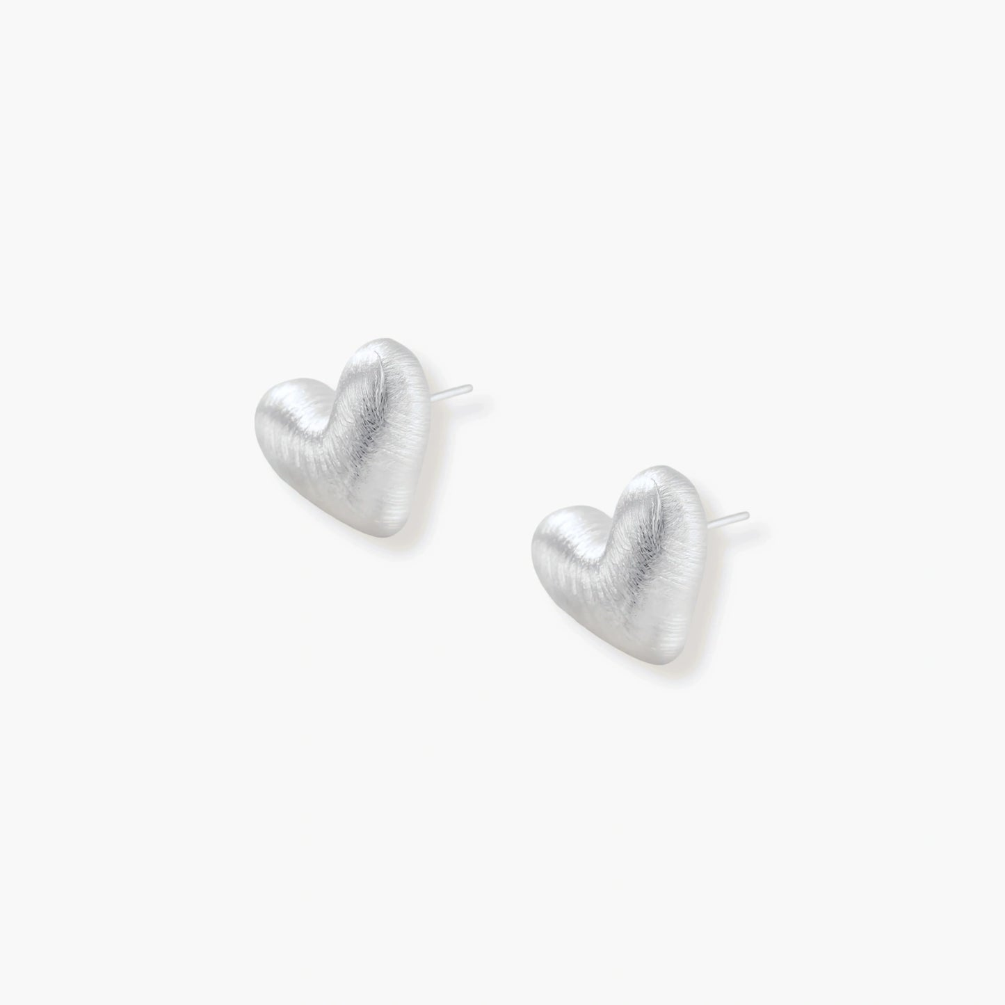 Pair of brushed platinum-plated 925 sterling silver puffy heart stud earrings on a cream background.