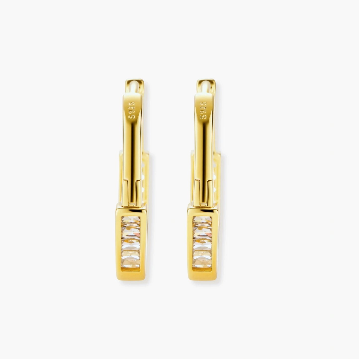 Close-up of gold-plated sterling silver huggie hoop earrings featuring rectangular cubic zirconia stones on neutral background.